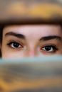 A mysterious and artistic close-up of a woman's eyes peeking through slats, capturing emotion.